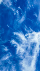 Fluffy white clouds float against a clear blue sky, evoking serenity and inspiration for environmental awareness and Earth Day