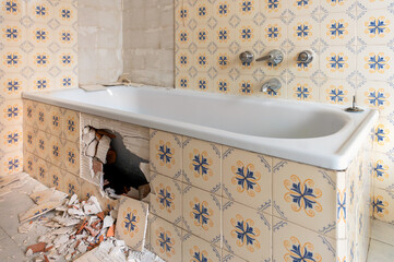Debris and broken tiles scattered on bathroom floor during home renovation