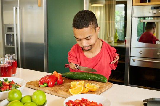 Man with phocomelia cutting vegetables