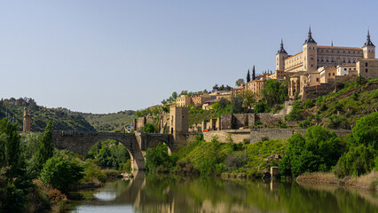 Historic bridge and the Alcázar of Toledo reflected in the Tagus River