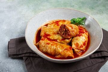 Stuffed cabbage rolls with minced meat, in tomato sauce, top view, without people, in the spotlight.