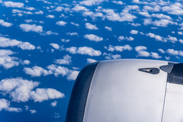 View of the clouds and blue sky from an airplane window.