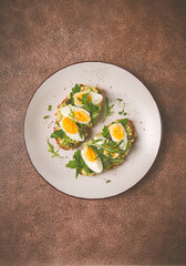 sandwich with mashed avocado, boiled egg, and arugula, on bread , homemade, breakfast,