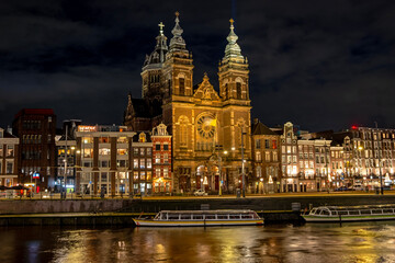 Fototapeta premium City scenic from Amsterdam by night with the St. Nicolas church in the Netherlands