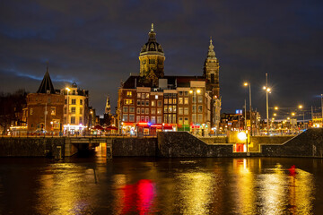 Obraz premium City scenic from Amsterdam by night with the St. Nicolas church in the Netherlands