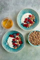 Breakfast, two bowls, yogurt, muesli with berries, and honey, homemade, no people,
