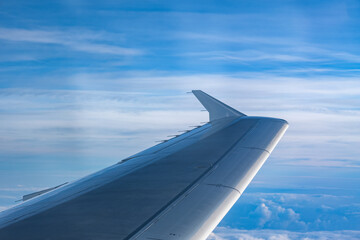 View of the clouds and blue sky from an airplane window.