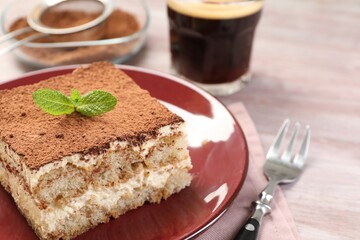 Delicious tiramisu with mint on light wooden table, closeup