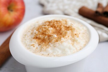 Delicious rice pudding with cinnamon on table, closeup