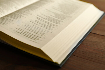 Open Holy Bible in English language on wooden table, closeup