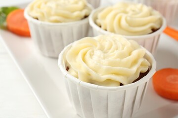 Tasty carrot muffins on white table, closeup