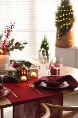 Christmas table setting with stylish dishware and festive decor indoors