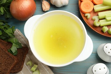 Tasty chicken bouillon served on light blue wooden table, flat lay