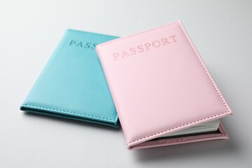 Passports in color covers on light background, closeup