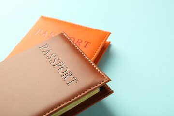 Passports in color covers on light blue background, closeup