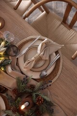 Christmas celebration. Festive table setting with dishware, glasses and decor in room, top view