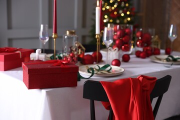 Christmas place setting with festive decor on table in room