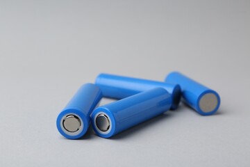 Many AA cell batteries on light grey background, closeup. Space for text