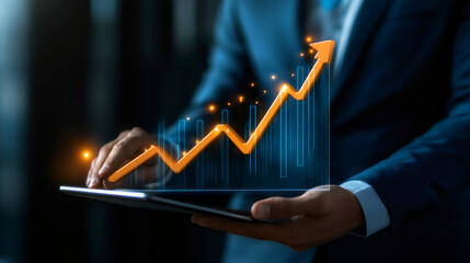 Businessman analyzing financial growth and investment success using a tablet with upward arrow chart showing positive business performance