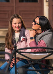 Happy mother and her teenage daughter spending fun time together , showing love and affection , cuddling and smiling. Family, single mom. Family bonding