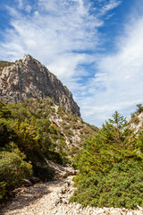 Trail to Cala Goloritze beach in Sardinia. Cliffs and blue sky. Hiking trail in the Baunei area at...