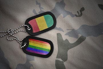 army blank, dog tag with rainbow gay pride flag and guinea on the khaki texture background. military concept.