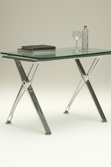 Photo studio d'un bureau en verre moderne avec pieds métalliques élégants, design minimaliste et lignes épurées, sur fond blanc
