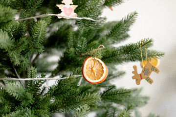 a piece of dried orange on a Christmas tree, close-up. DIY eco decorations for the Christmas tree