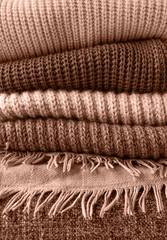 Mocha Mousse - color of the year 2025. Stack of autumn warm sweaters