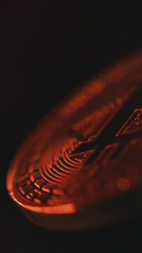 Vertical shot of gold bitcoin coin spinning on the black background. Digital cryptocurrency virtual money. Blockchain modern technology. P2P bitcoin trading. BTC logo. Mining and investment. Slow