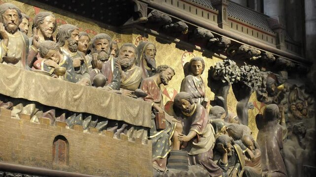 Intricate medieval sculpture of biblical figures in Notre Dame Cathedral, Paris, depicting diverse activities and narratives