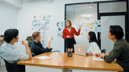 Young beautiful leader presents marketing strategy while expert investor and project manager listening and lecturing to analyze business performance at start up business meeting. Immaculate.