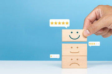 Service rating, satisfaction and positive feedback concept. A man choose smile face emoticon give a five star rating indicates the highest level of satisfaction