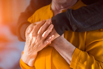 Man support his old grandmother, holds her hands.