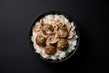 A photo of cooked rice with meatballs and mushroom sauce in a bowl