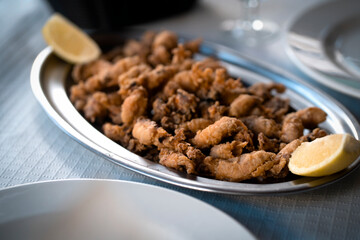 A plate with fried small delicious cuttlefish, grilled seafood closeup.