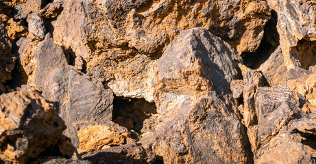Lava formations, stones, black basalt in the rocks closeup on a volcano terrain.