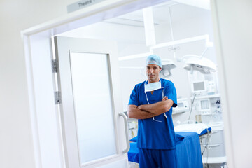 Obraz premium Pride, portrait and doctor as surgeon in theatre for heart transplant, cardiology and operation, Male person, medical professional and specialist for clinic, surgery and healthcare with arms crossed
