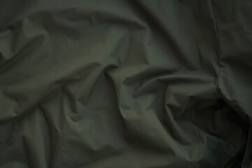 Texture of Dark green military uniform textile cloth with folds