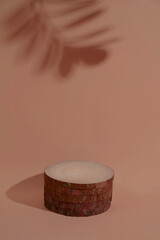 Round wooden podium on background in Mocha Mousse color for product. Monochrome creative composition with shadow. Front view. Copy space