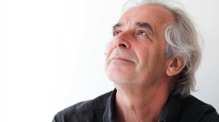 Mature man reflecting on happy memories with a serene expression against a white background evoking positive emotions and nostalgia.