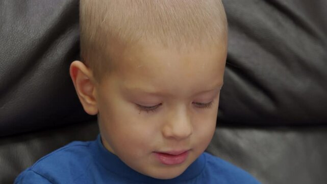 Child holding a box with new toy. Three year old boy saying something.