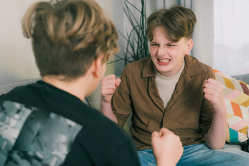 Aggressive quarrel, argument with shouts between teenage brothers at home. Relationship between...