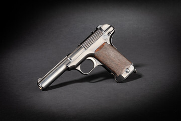 Studioaufnahme einer Savage Mod. 1907 historischen Pistole Kurzwaffe auf schwarzem Untergrund mit Schlagschatten dramatischen Licht
