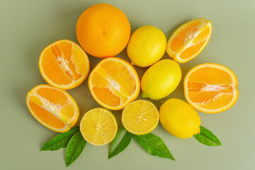 Orange oranges and yellow lemons on a green background. Citrus fruits