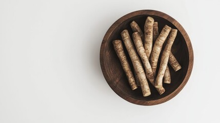 Burdock root Gobo displayed in a wooden plate on a clean white background showcasing natural food ingredients for culinary use