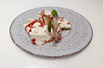 Meringue and mascarpone dessert on dish on white table