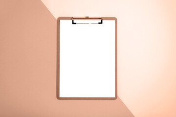 Clipboard with blank paper on brown and beige background. Top view, flat lay, mockup