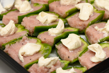 Delicious green bell peppers filled with savory meat mixture and creamy topping ready for baking