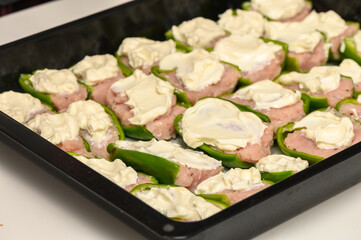 Stuffed green peppers filled with creamy goodness, ready for baking in a cozy kitchen setting